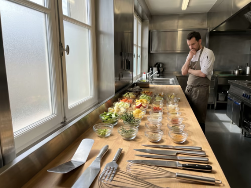 Cortar verduras: ¿Cómo hacerlo rápido y fácil? 7 Chef de restaurante observando una larga fila de cuencos con verduras ya cortadas y preparadas para el servicio, con cuchillos profesionales en primer plano