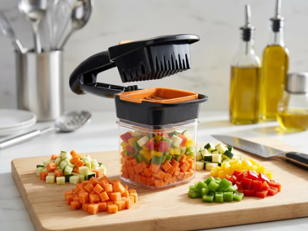 Cortar verduras: ¿Cómo hacerlo rápido y fácil? 6 Recipiente transparente lleno de dados multicolor de zanahoria, pimiento rojo, amarillo, verde y pepino cortados con picador manual sobre tabla de bambú